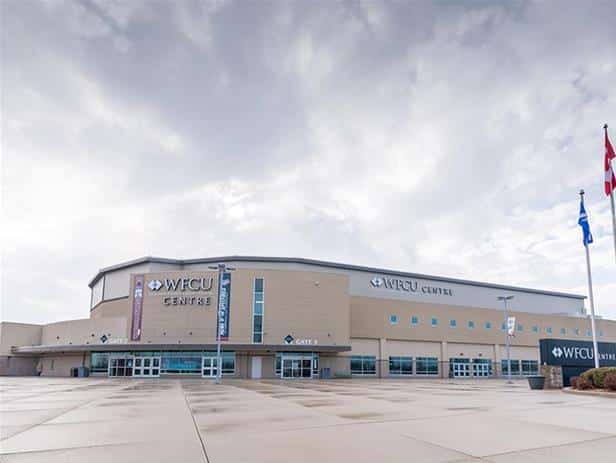 Exterior view of WFCU Centre, a large multi-purpose arena, under a cloudy sky with flags and banners visible, showcasing one of the top Windsor attractions in the City of Windsor.