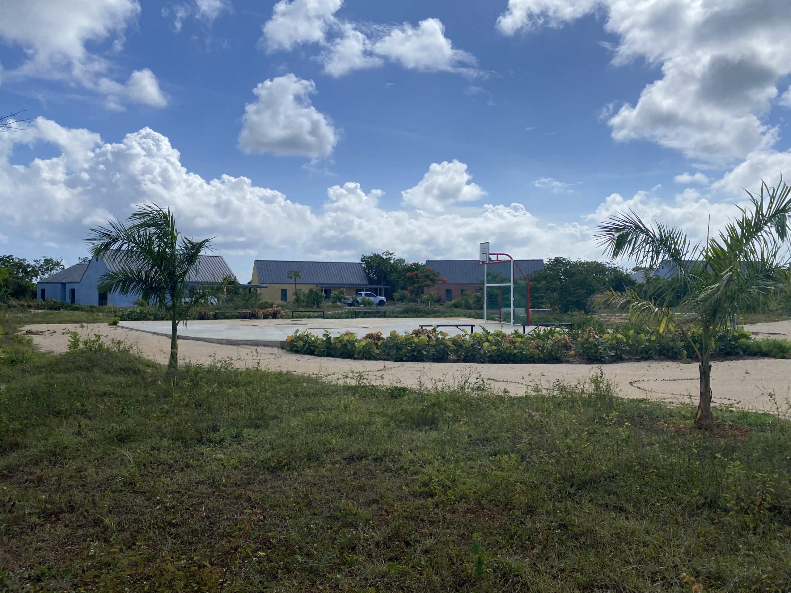 Exterior view of the Poinciana Rehabilitation Centre showing multiple buildings and a large green space.